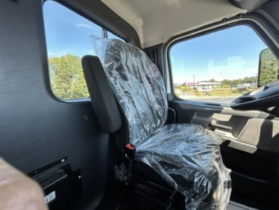 Cab interior of a 2022 Freightliner Cascadia 126 Day Cab showing plastic-covered driver seat and front door panel.