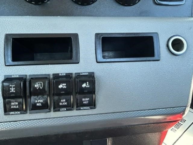 Dashboard switch panel with multiple labeled switches and two empty display slots. Visible text on switches includes LOCK, INTR AXLE, K-PIN REL, AIR SLIDE, SUSP. HGT, LOWER, U NLOCK, and icons.