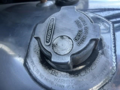 Diesel fuel cap on Freightliner Cascadia fuel tank shows 'FREIGHTLINER' and 'DIESEL FUEL ONLY' markings with warning text embossed around cap.