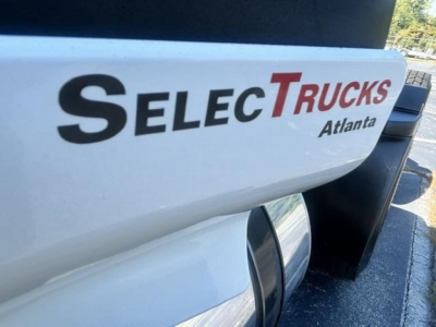 Truck badge showing SelecTrucks Atlanta branding on a white Freightliner Cascadia day cab