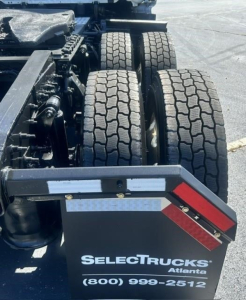 Truck rear view showing tandem axle wheels and wheel mud flaps with Reflective strips and SelectTrucks Atlanta branding.