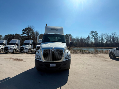 International Prostar truck front view showing grille, headlights, and cargo cab in a parking lot.