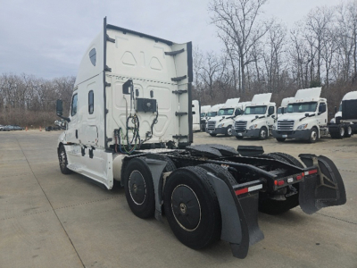 Truck tractor cab view from rear-left showing fifth wheel and rear axles of a Freightliner Cascadia126 with white exterior.