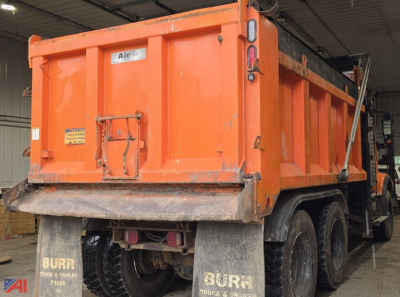 Volvo VHD dump truck rear view showing orange dump body, mud flaps, dual rear wheels, and tailgate with Airflo sticker.