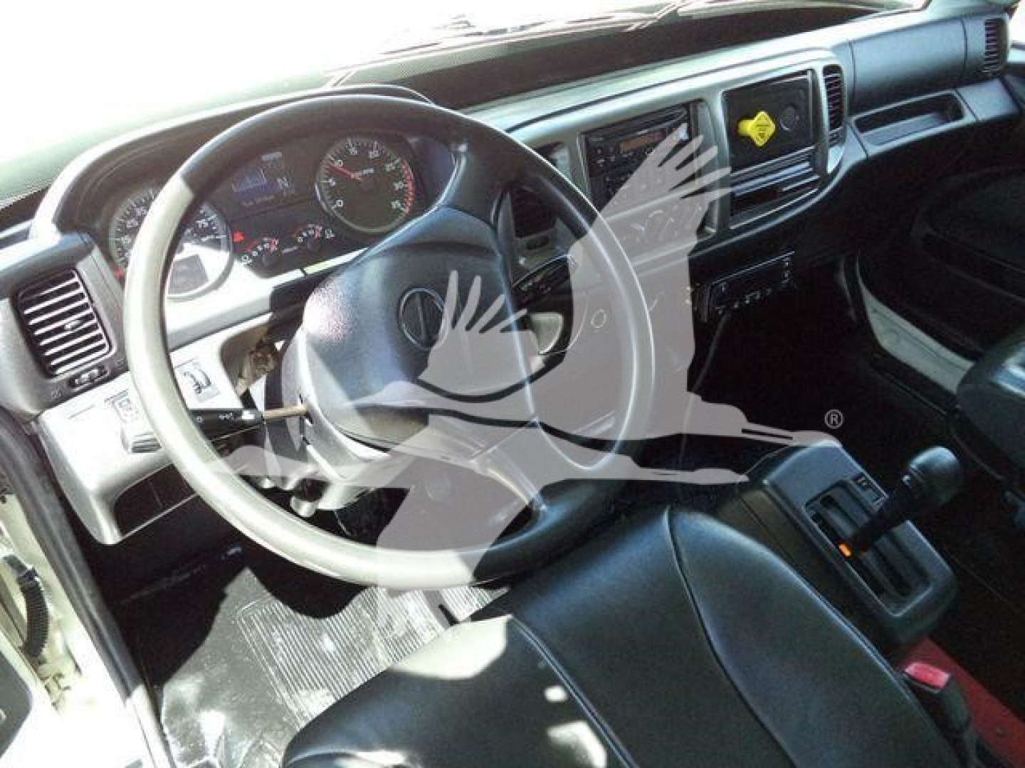 Interior of a 2015 Hino 268A including steering wheel, dashboard gauges, and center console.