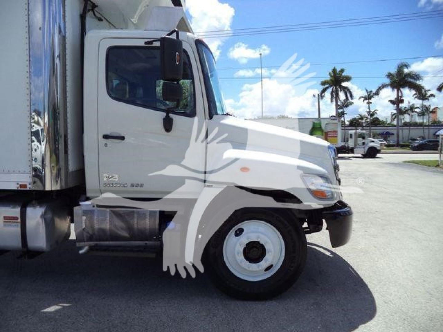 Truck side profile showing cab and front wheel of a 2015 Hino 268A refrigerated truck.