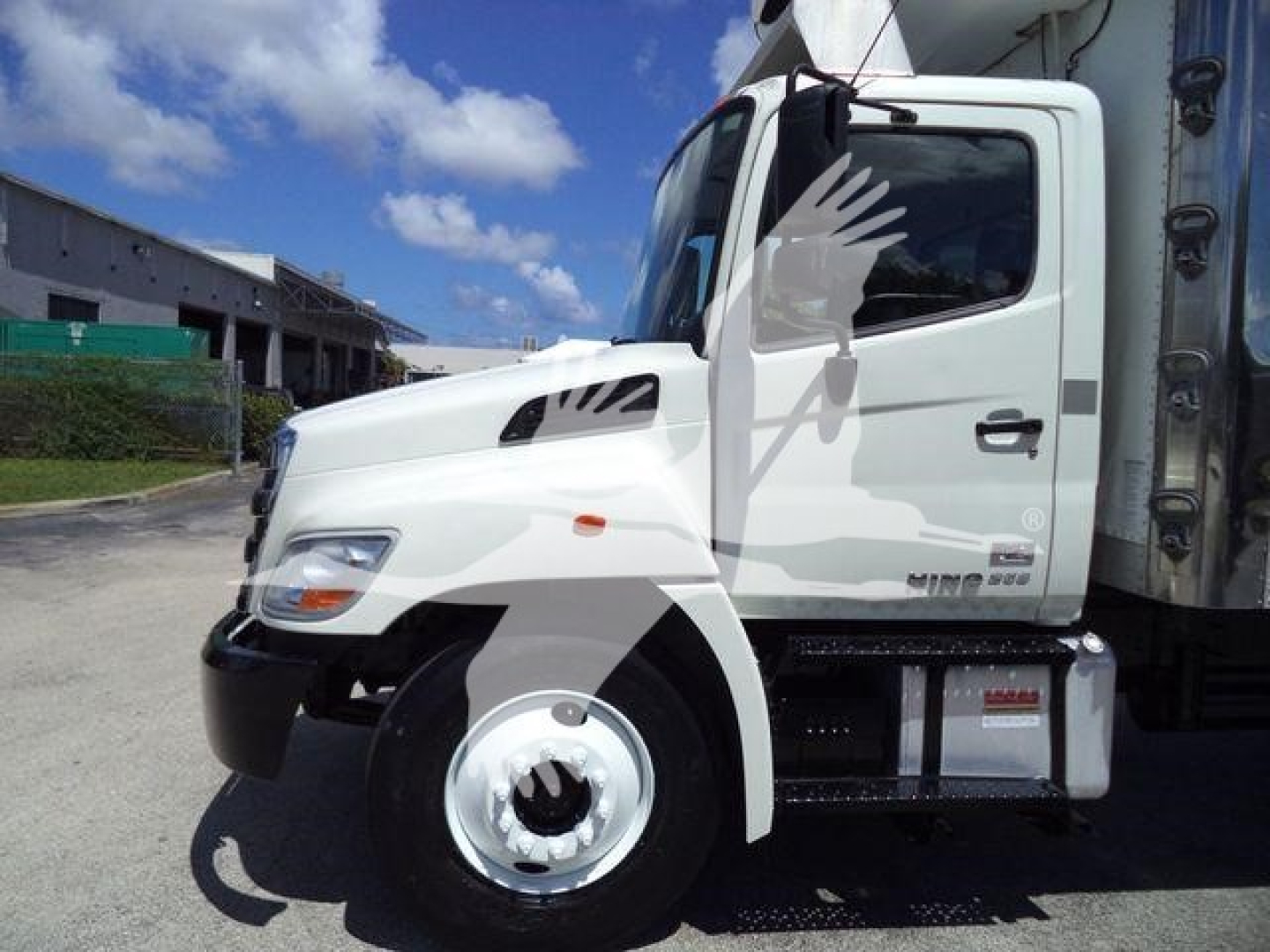 Truck front-left side of a 2015 Hino 268A refrigerated truck showing cab and side step.
