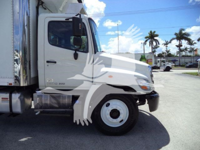 Truck side profile showing cab and front wheel of a 2015 Hino 268A refrigerated truck.