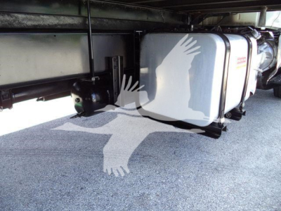 Undertruck view of a refrigerated truck chassis showing multiple white insulated tanks with black brackets. No legible branding or numbers visible.