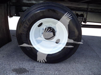 Tire and white steel wheel on Hino 268A refrigerated truck hitch area visible