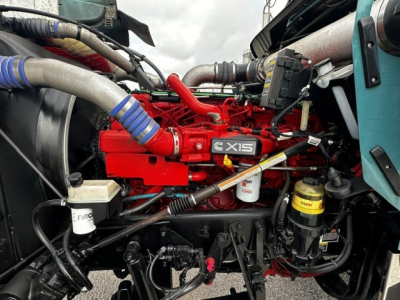 Kenworth W900L engine bay showing red 4X15 engine block with various hoses, filters, and an oil reservoir visible.