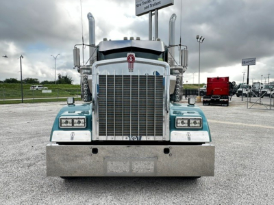 Kenworth W900L truck front view showing large chrome grille, upright exhaust stacks, dual rectangular headlights, and metal bumper.