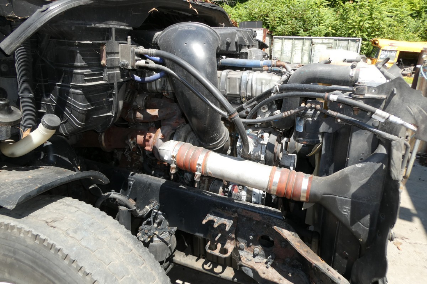 Engine bay of a Freightliner Cascadia 125 truck showing intake hoses, turbo, coolant reservoir, and radiator components.