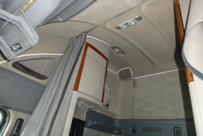 Cabin interior of a 2014 Freightliner Cascadia 125 sleeper truck showing overhead storage, light fixtures, and quilted headliner.