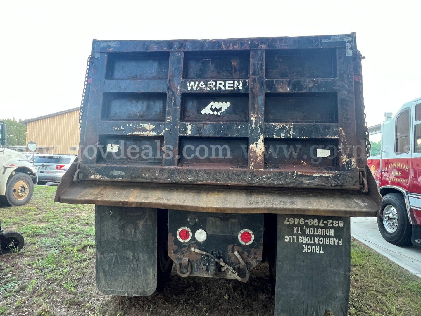 Truck bed rear view showing Warren dump truck with spare lights and mud flaps.