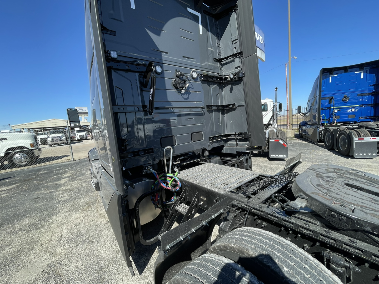 Volvo VNL64T860 truck cab and fifth wheel area with rear view showing chassis and hoses, no cab interior text visible.