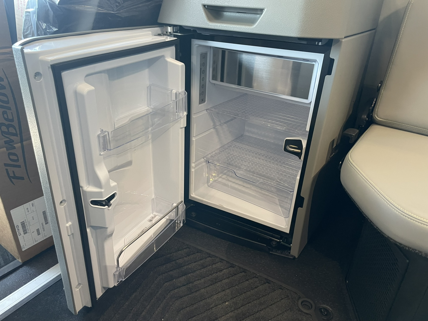 Mini fridge/freezer unit in Volvo VNL64T860 cab showing open door and empty shelves
