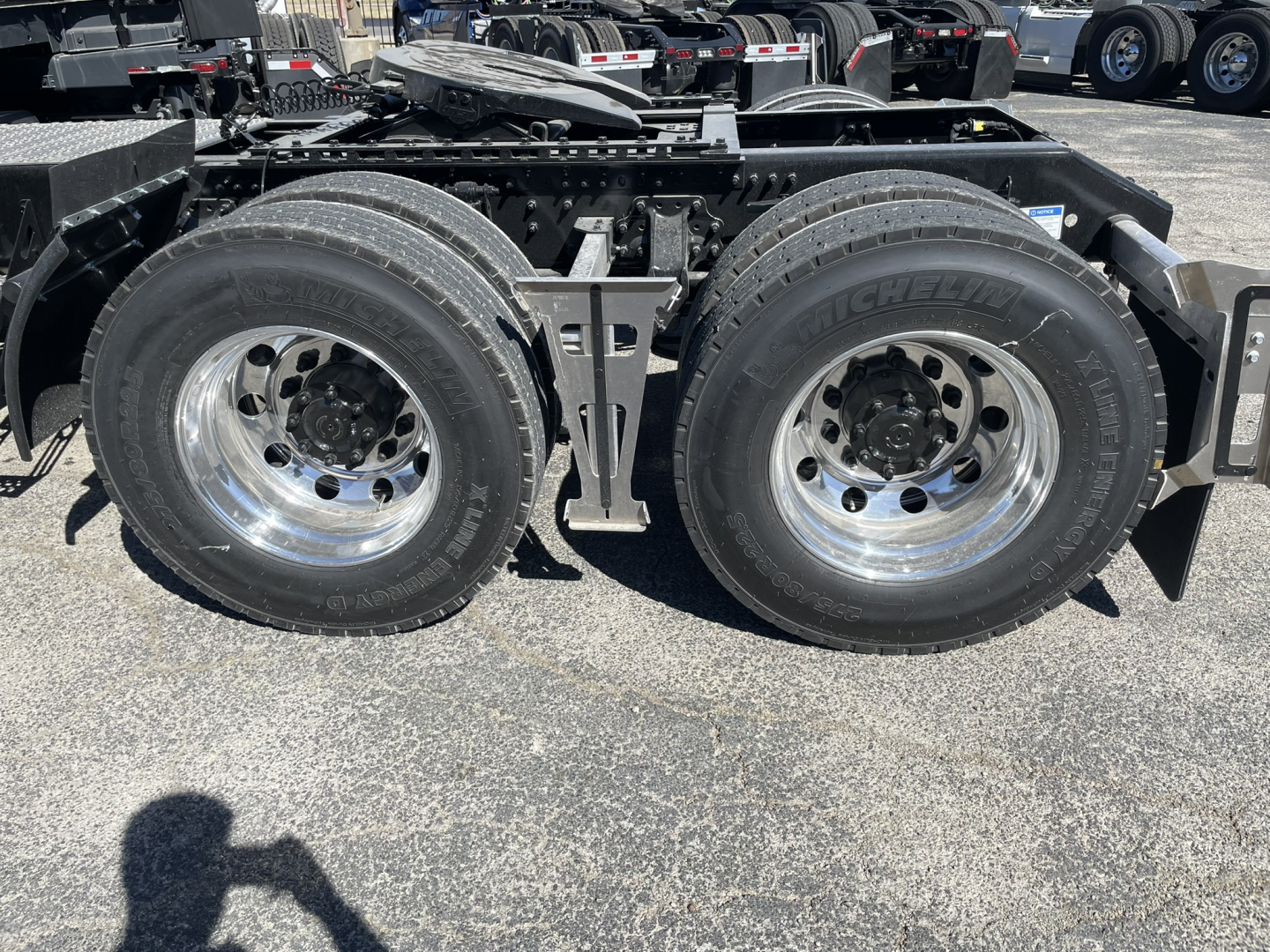 Dual rear wheels on a Volvo truck chassis showing tires, wheels, and frame with hydraulic lines and mounting brackets visible.