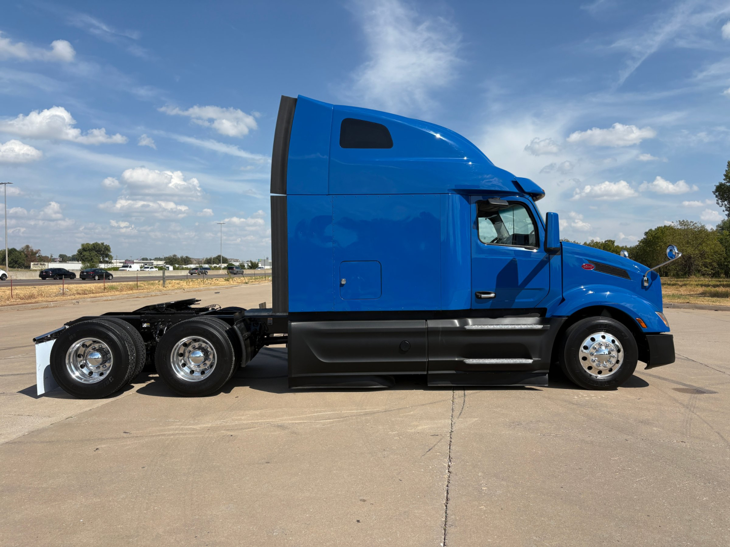 Peterbilt 579 tractor in blue side view showing sleeper cab and 6x4 axle configuration.