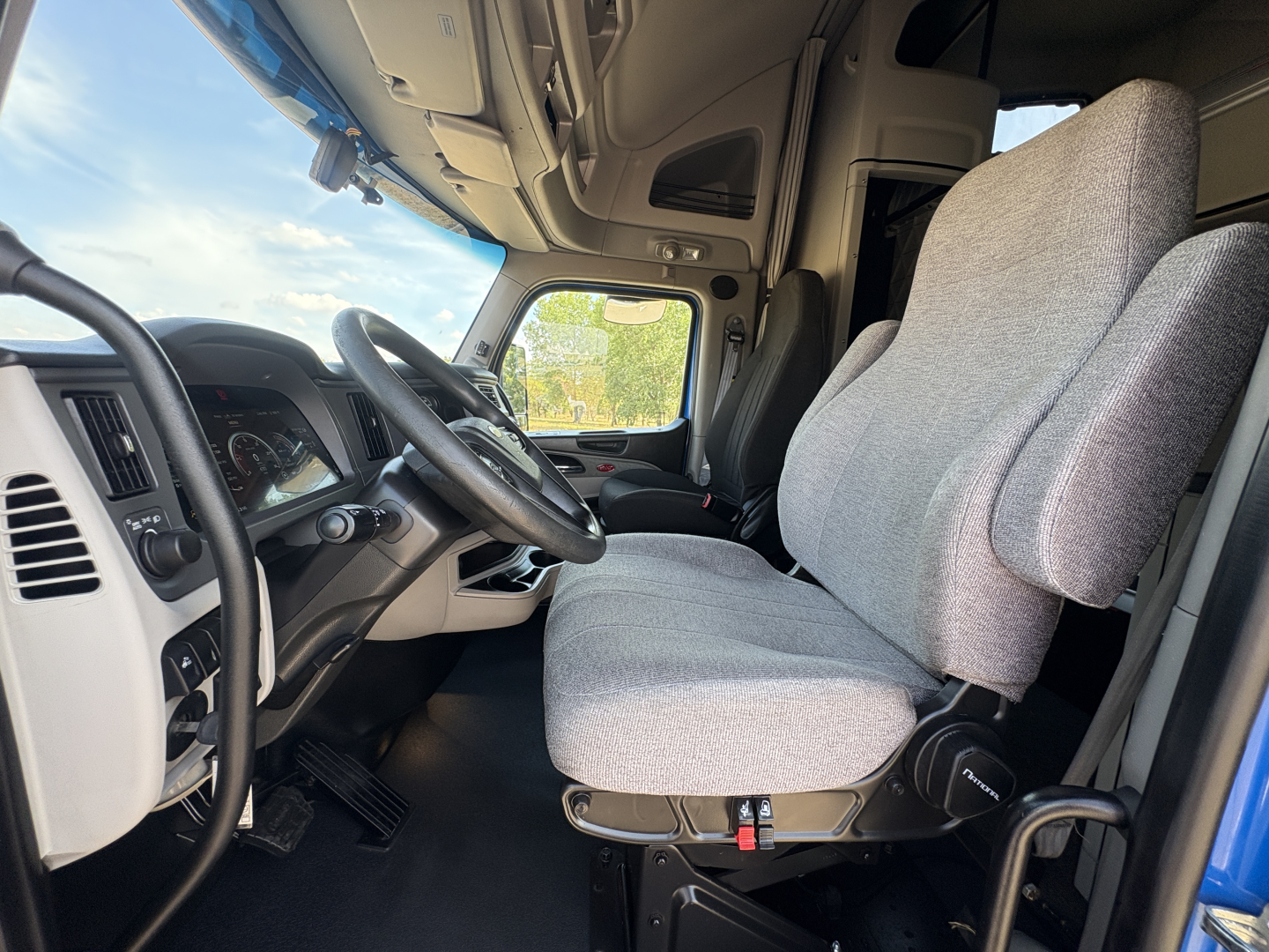 Peterbilt 579 truck interior showing driver seat and steering wheel with dashboard and large side window