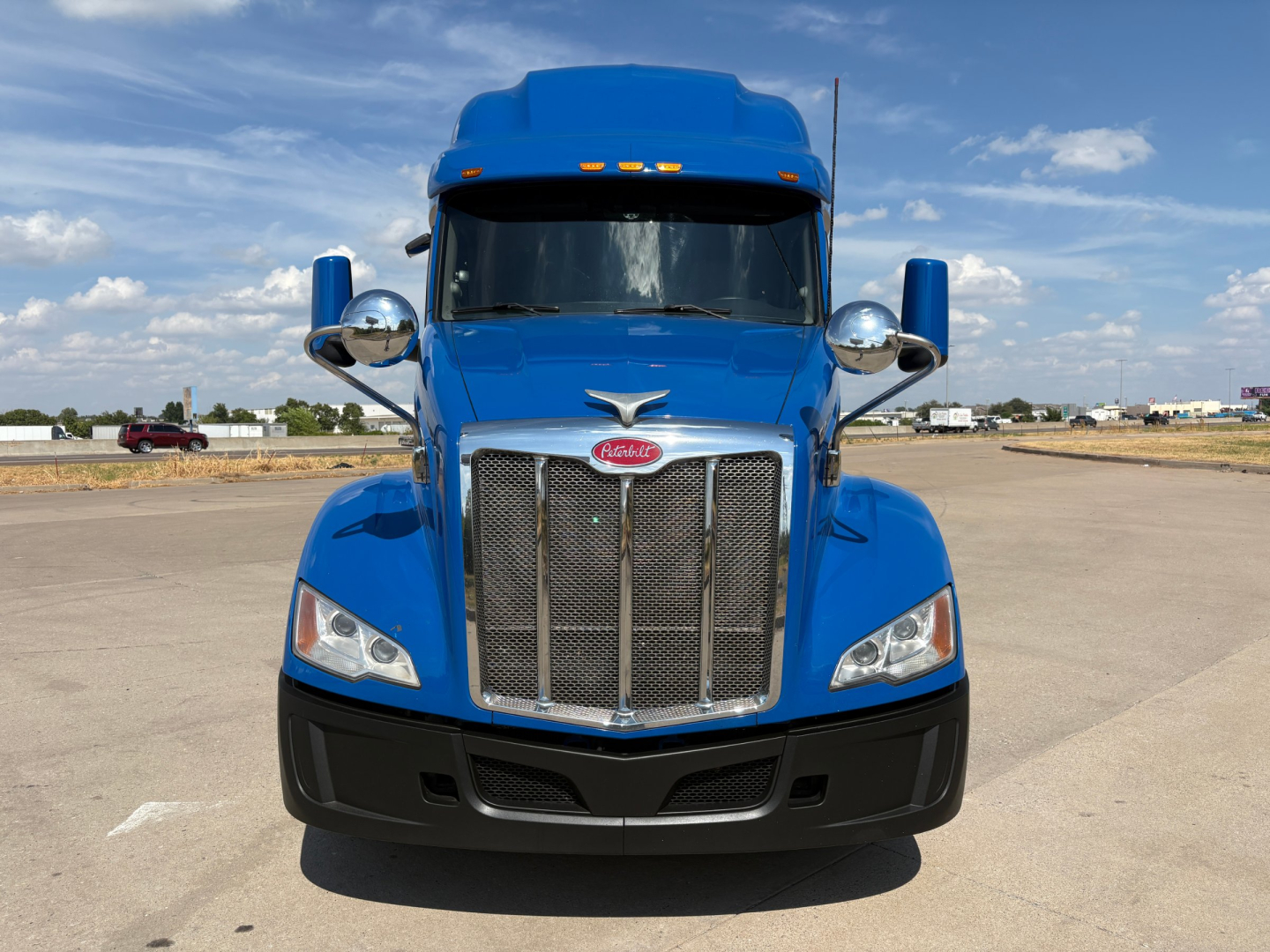 Peterbilt 579 truck head-on in blue showing chrome grille and headlights.