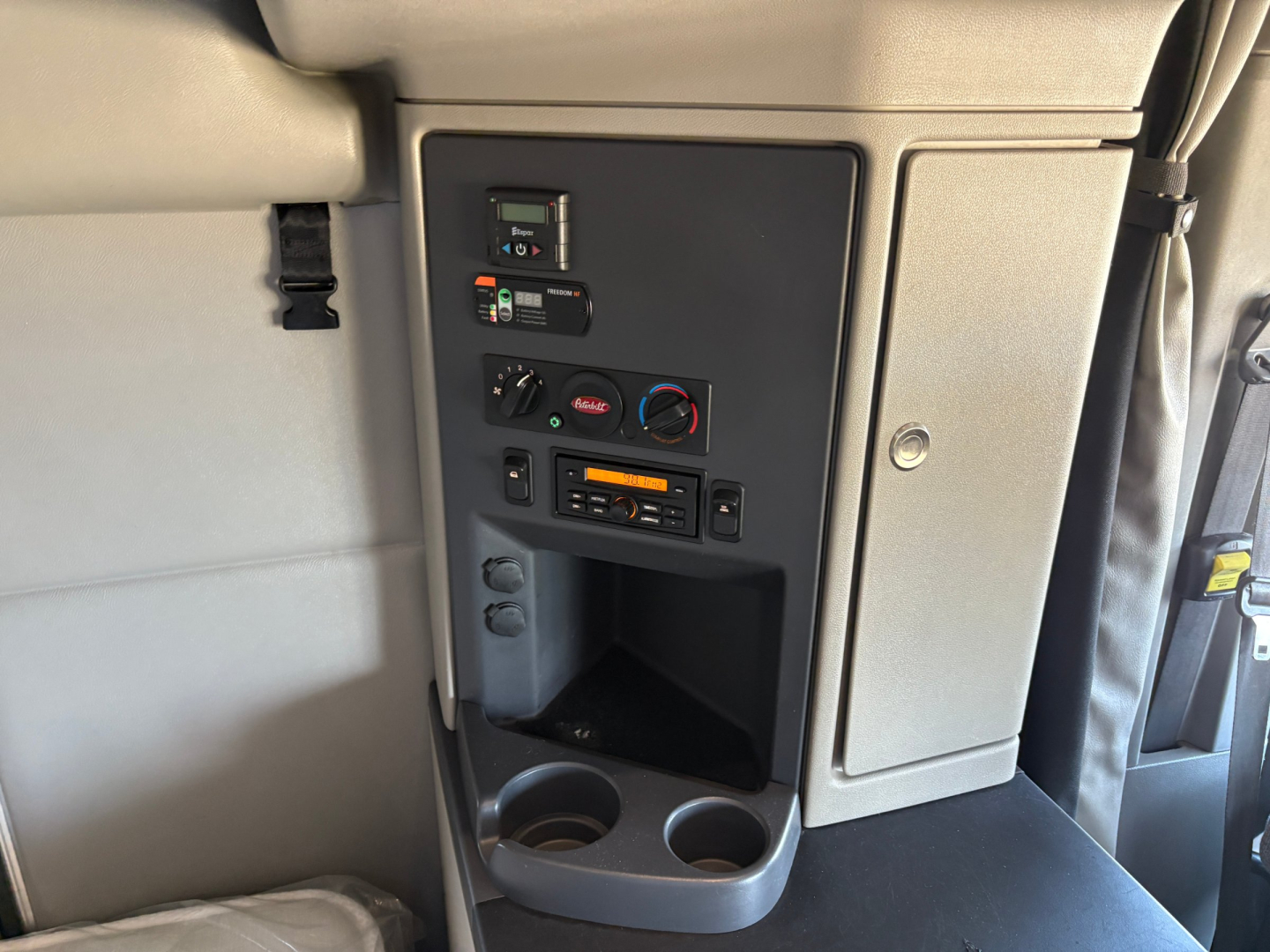 Peterbilt 579 interior cab panel showing climate controls, radio, and storage compartments.