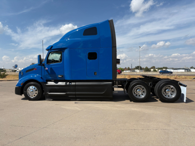 Peterbilt 579 semi-truck in blue, side view, sleeper cab, 3-axle chassis, wheels and tires visible.