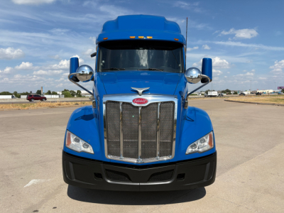 Peterbilt 579 truck head-on in blue showing chrome grille and headlights.