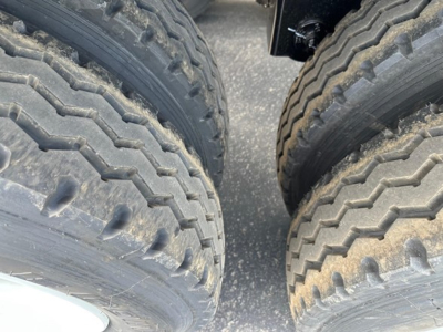 Dual axle trailer tires and suspension view for a Manac combo drop deck showing tread pattern.