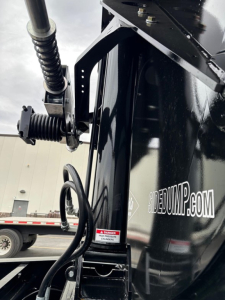 Manac combo drop deck trailer showing hydraulic landing gear and side branding with 'SIDEPUMP' lettering visible on the black frame.