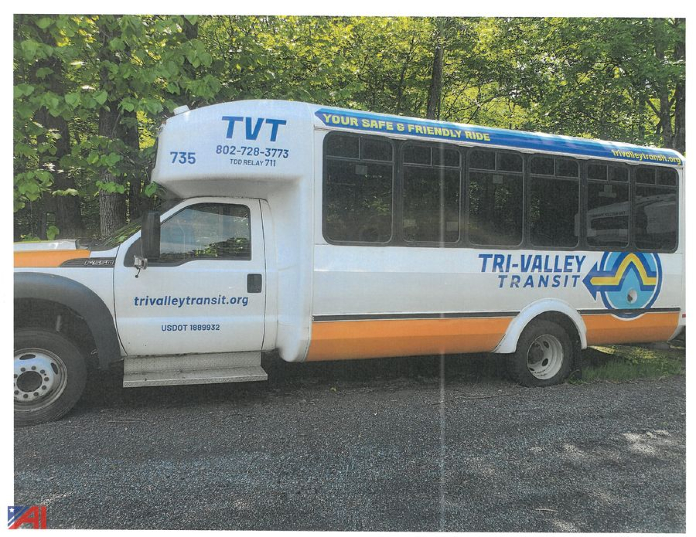 Bus side view showing Tri-Valley Transit logo, blue and orange livery, TVT branding, TR Valley Transit text, bus windows, and front cab with US DOT numbers.