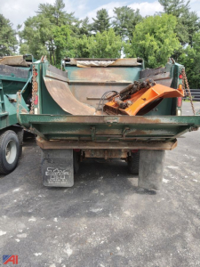 Dump truck bed with plow attachment and chains, rear view of 2010 Mack Granite used truck in an outdoor yard.