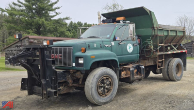 GMC TopKick dump truck in service showing side profile with green cab and dump bed, front bumper and wheels visible.