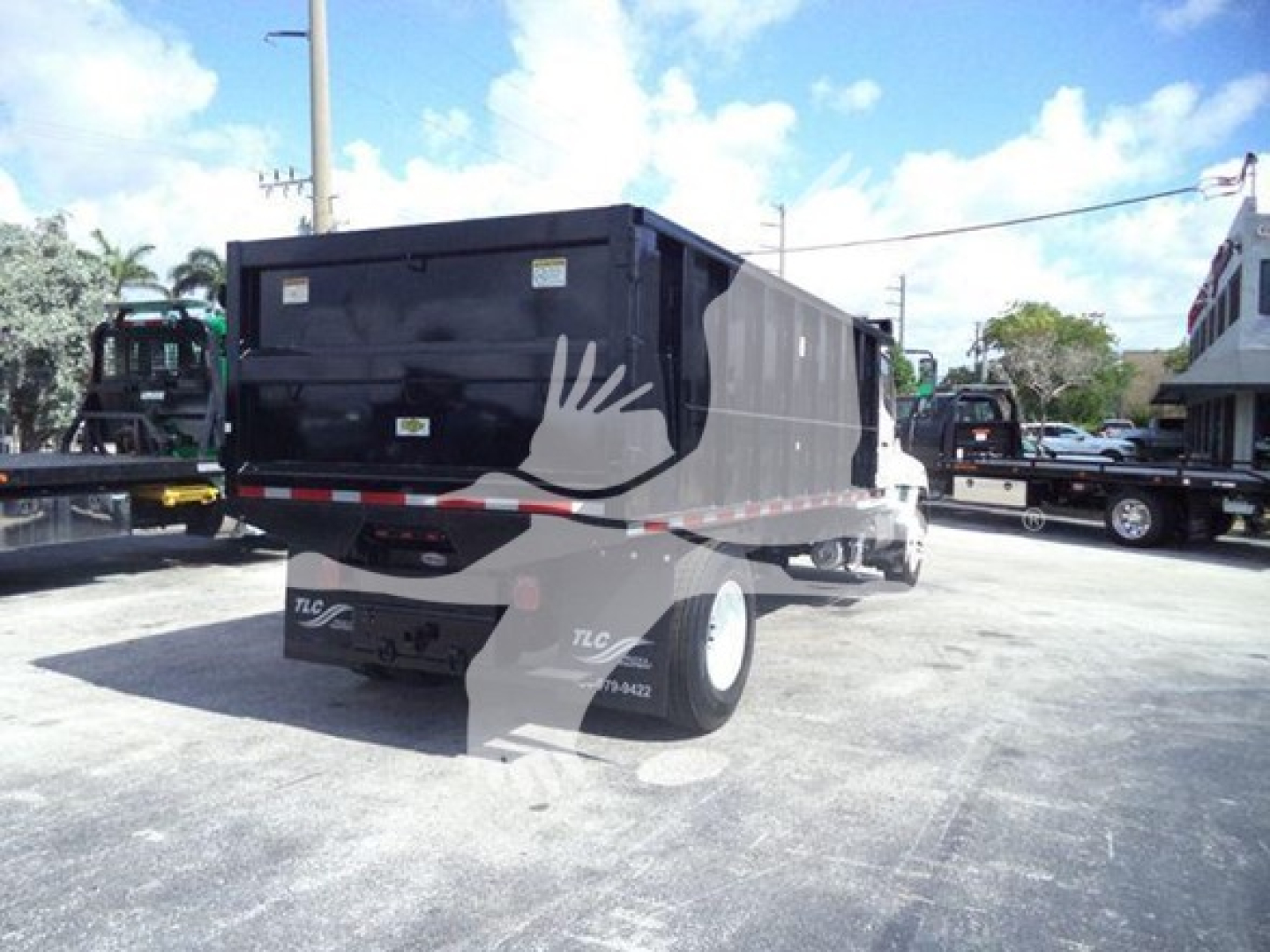 Truck bed of a 2016 Hino 268A dump truck showing rear and side view.