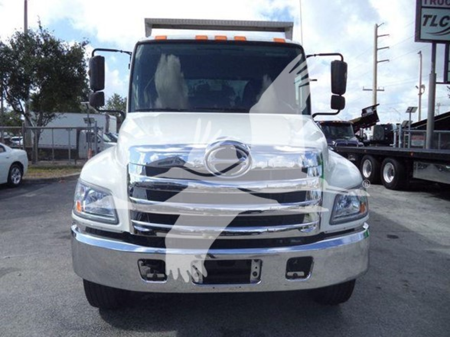 Front view of 2016 Hino 268A dump truck showing chrome grille, headlights, and bumper with blank license plate area.