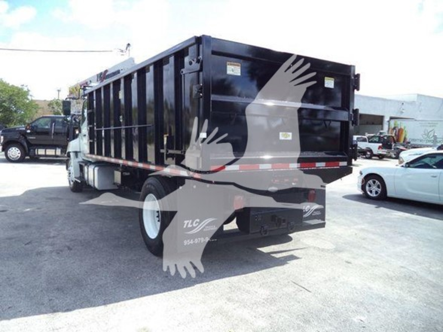 Dump truck 2016 Hino 268A rear-left view showing dump bed and dual rear doors with stock number T57015 and VIN 5PVNJ8JT6G4S57015.