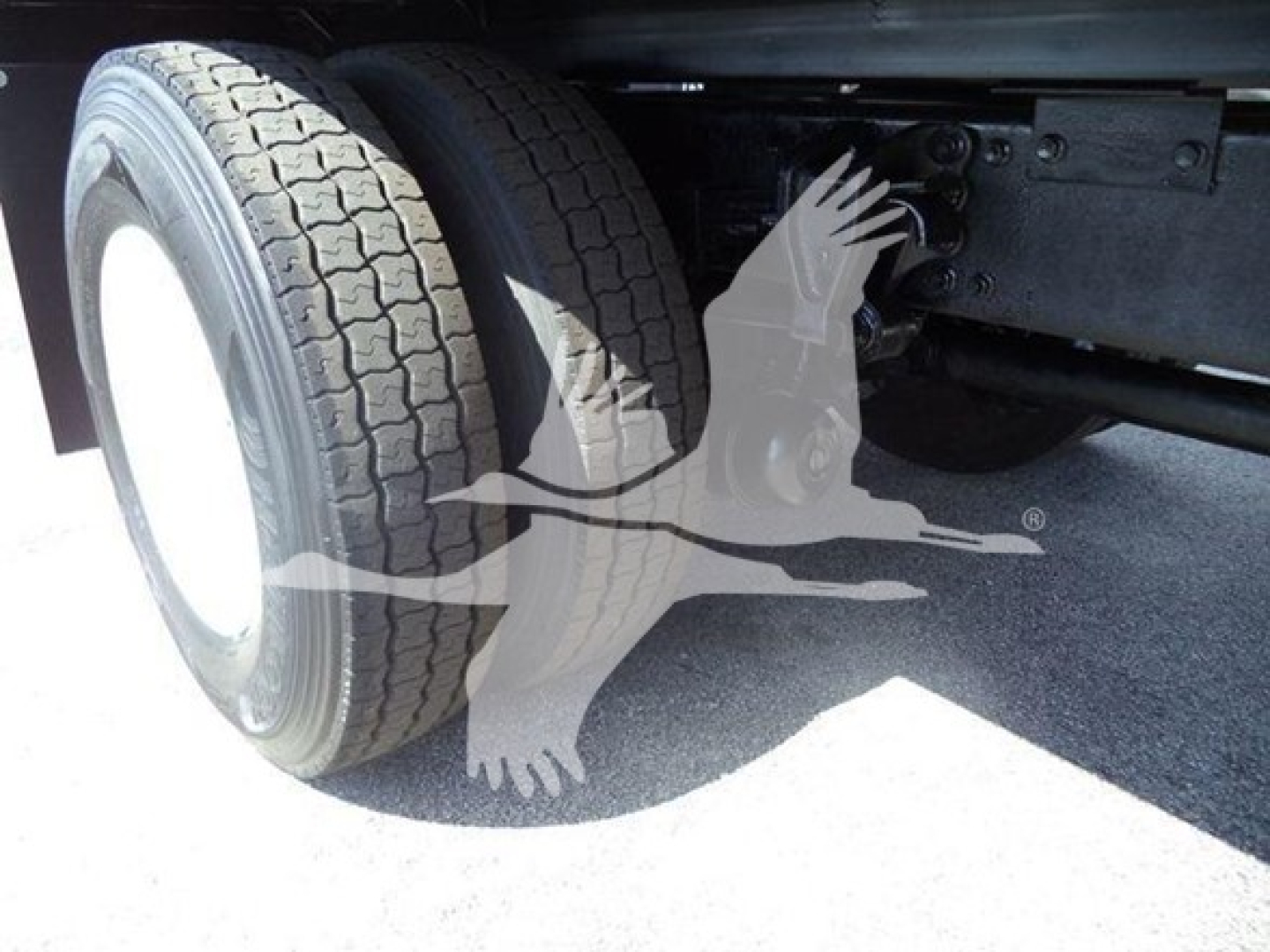 Truck rear dual wheels on a 2016 Hino 268A dump truck showing the left rear tire and chassis.