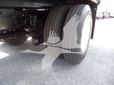 Truck axle and dual rear tires area of a 2016 Hino 268A dump truck showing twin wheels and suspension components.