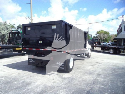 Truck bed of a 2016 Hino 268A dump truck showing rear and side view.