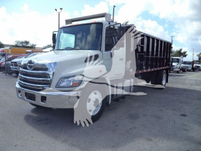 2016 Hino 268A dump truck front-left view showing chrome grille, cab, and dump bed with black sides.