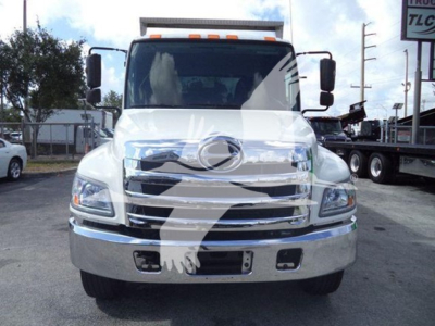 Front view of 2016 Hino 268A dump truck showing chrome grille, headlights, and bumper with blank license plate area.
