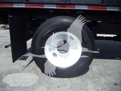 Rear wheel and undercarriage of a 2016 Hino 268A dump truck showing wheel and tire with reflective side panel.