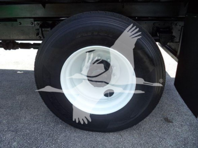 Wheel with white rim and tire under truck chassis; no legible labels or text visible on components.