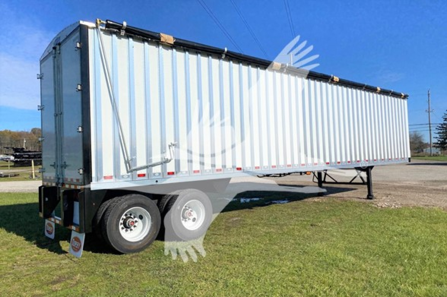 Trailer showing a long aluminum walking floor trailer with quad rear wheels and a black top rail, side framing, and hanging mud flaps. VIN 7KYCW4527VED48297 visible on listing.
