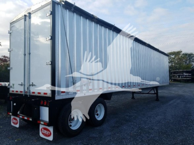 Truck trailer showing Dorsey walking floor trailer with blue sides and white graphic, rear view, dual axles and landing legs visible.