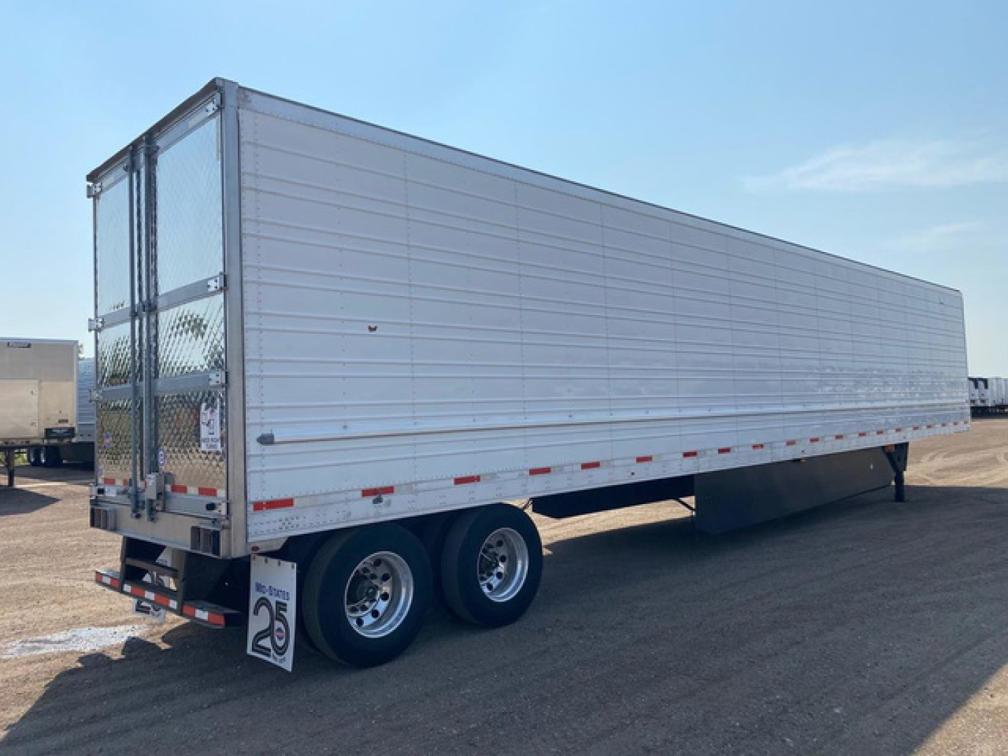 Trailer side view showing refrigerated utility reefer trailer with silver exterior and dual rear axles.