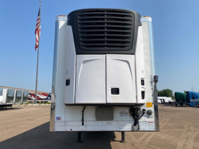 Refrigerated trailer front view showing unit with black grille, white body, and legs.