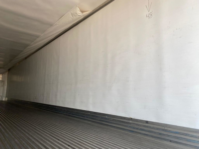 Refrigerated trailer interior showing smooth sidewall and floor ribs of cargo area.