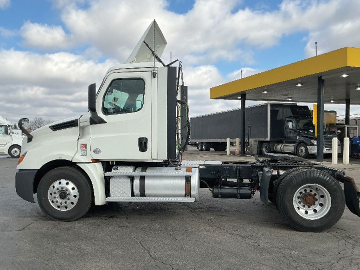 Freightliner Cascadia126 truck cab and chassis side view showing clean white cab and exposed fifth wheel area