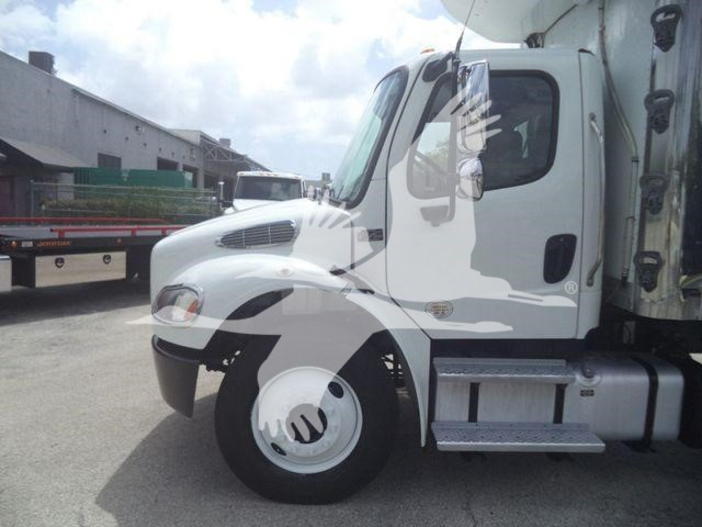 Freightliner M2 106 cab in-service showing side steps and front wheel with standard hubcap.
